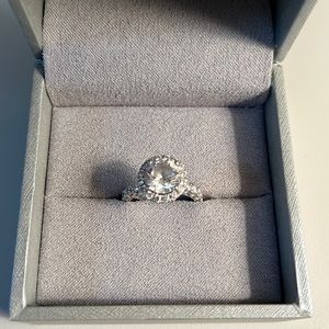 Cubic Zirconia center stone. White stone diamonds on mounting.